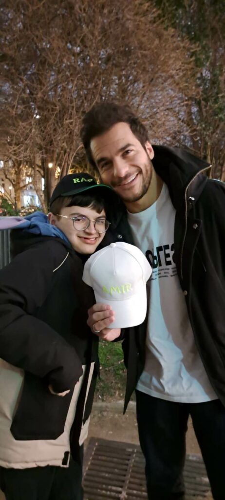 Photo de Raphy avec son idole le chanteur Amir lui remettant les cadeaux que nous lui avons fait parvenir pour qu'il puisse offrir sa casquette a Amir