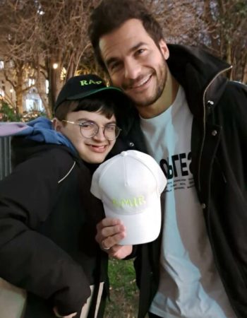 Photo de Raphy avec son idole le chanteur Amir lui remettant les cadeaux que nous lui avons fait parvenir pour qu'il puisse offrir sa casquette a Amir